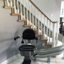 Stairlift waits for recipient at the bottom of stairs.